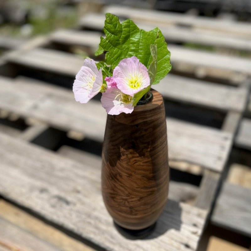 Wooden vase with flowers pictured outside on wooden pallets