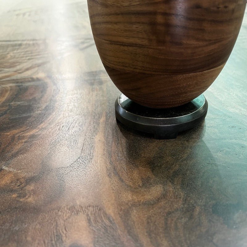 Wooden vase showing its bronze base