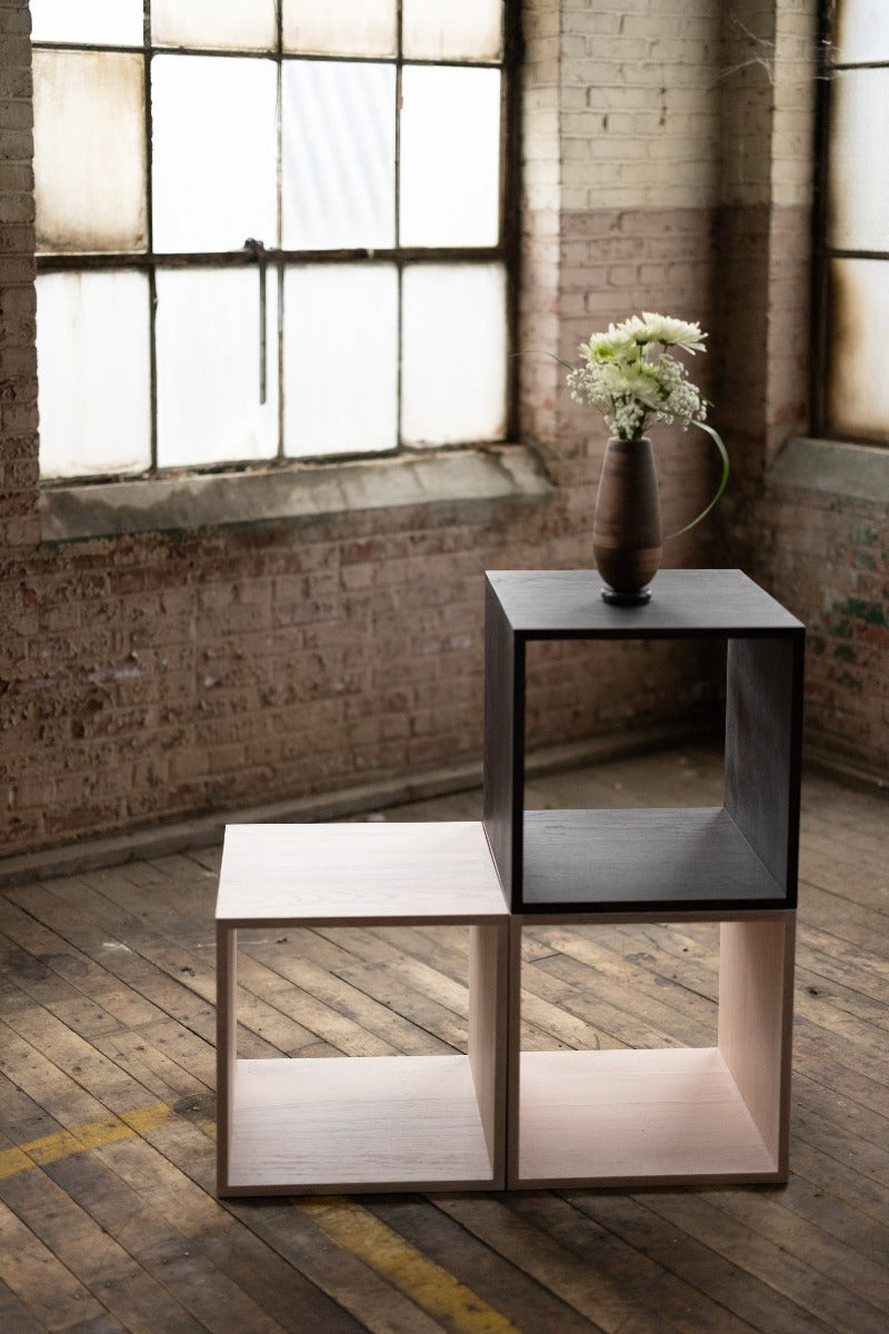 configuration of stackable wooden storage cubes black and white with vase