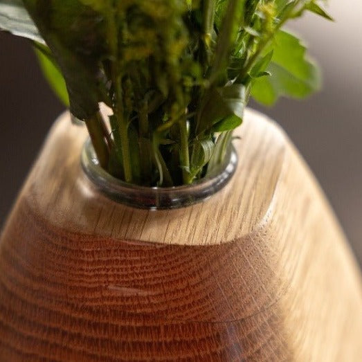 Wooden vase zoomed in to the glass insert with flowers