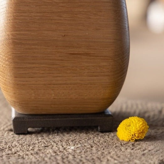 Wooden vase showing it's bronze base