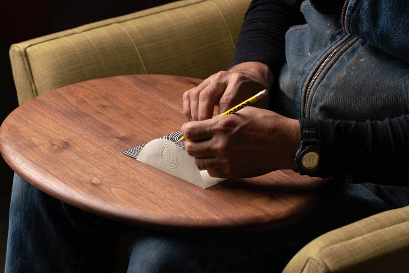 a man using the Wooden Lap Desk to write a greeting card.