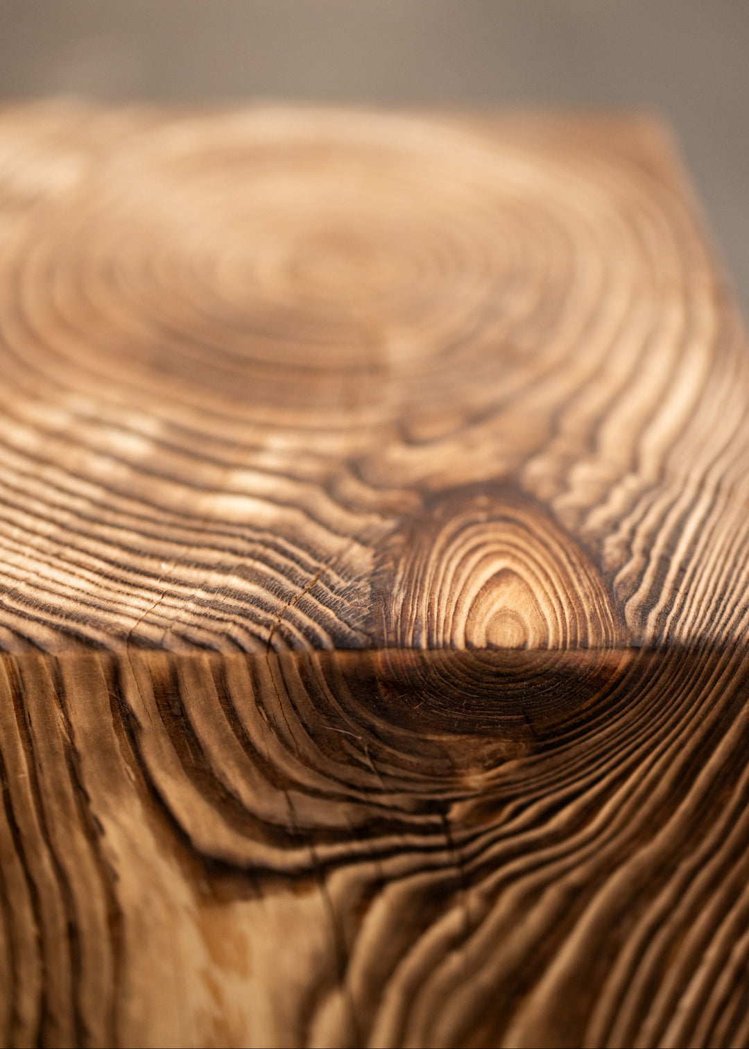 Close-up of a wooden cube side table with visible grain and texture