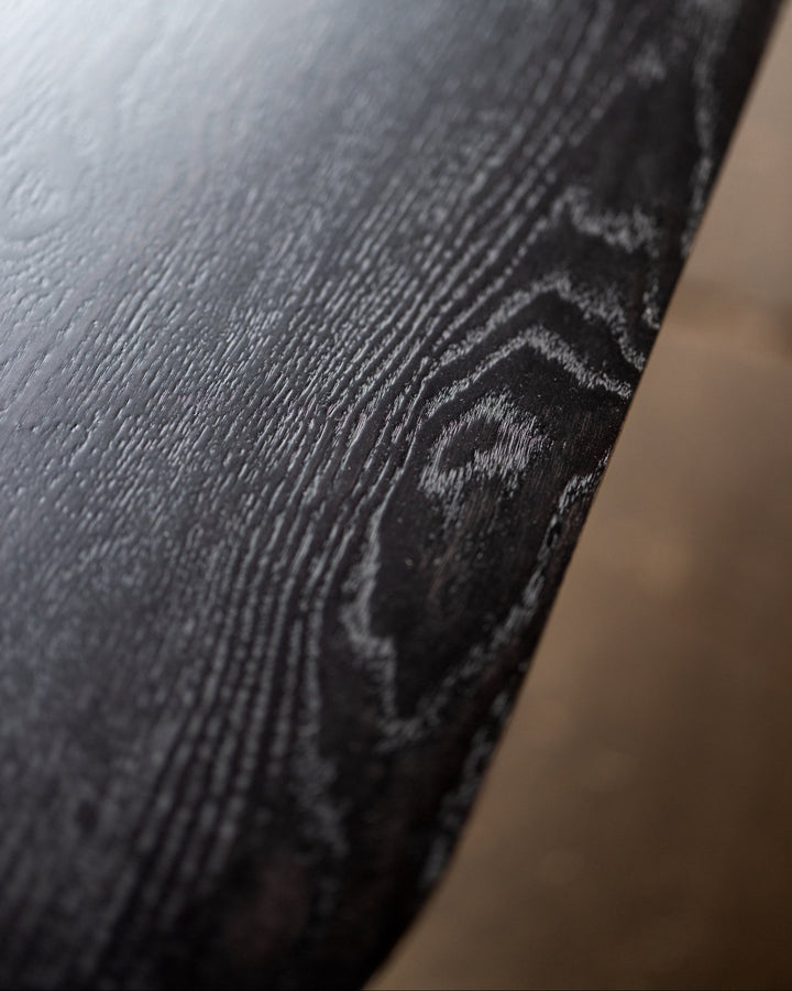 Close-up of a dark wooden surface with visible grain.