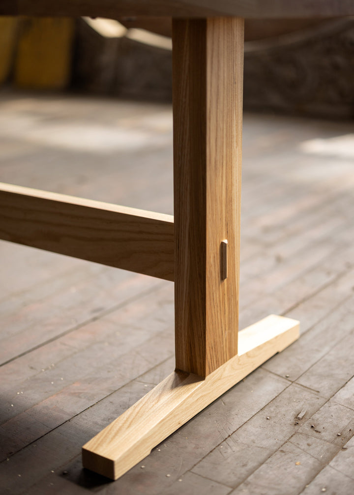 Wooden shaker style  table leg on a wooden floor