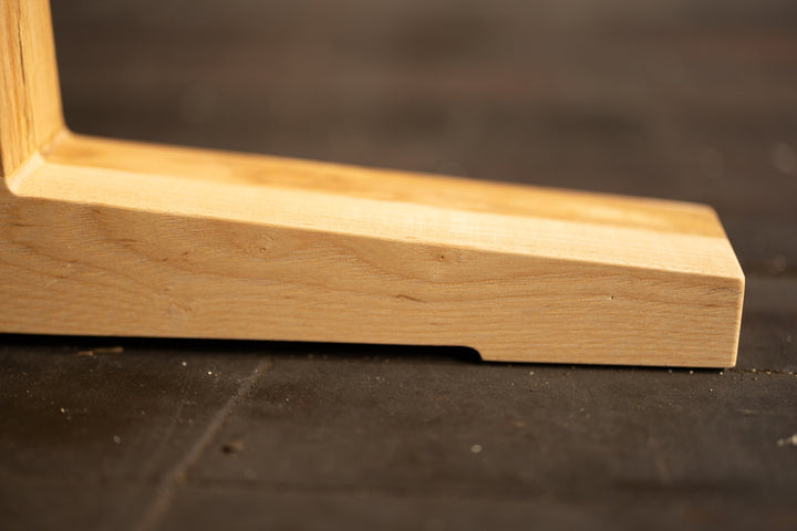 Close-up of a wooden table base corner on a dark surface