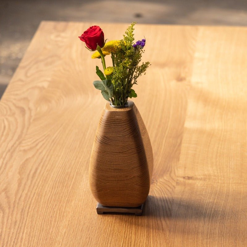 Wooden vase with flowers pictured on a wood table